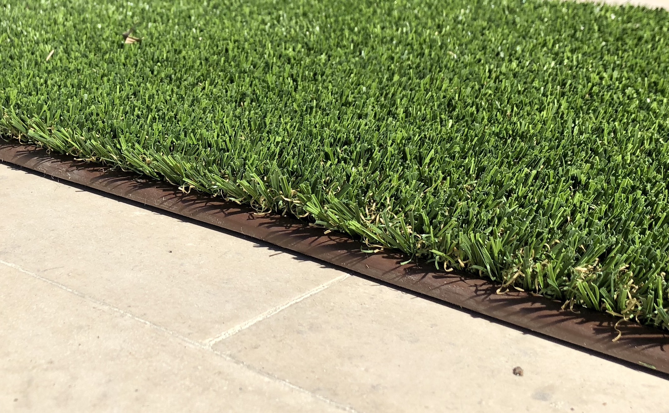 artificial lawn border transitions between artificial turf and cement